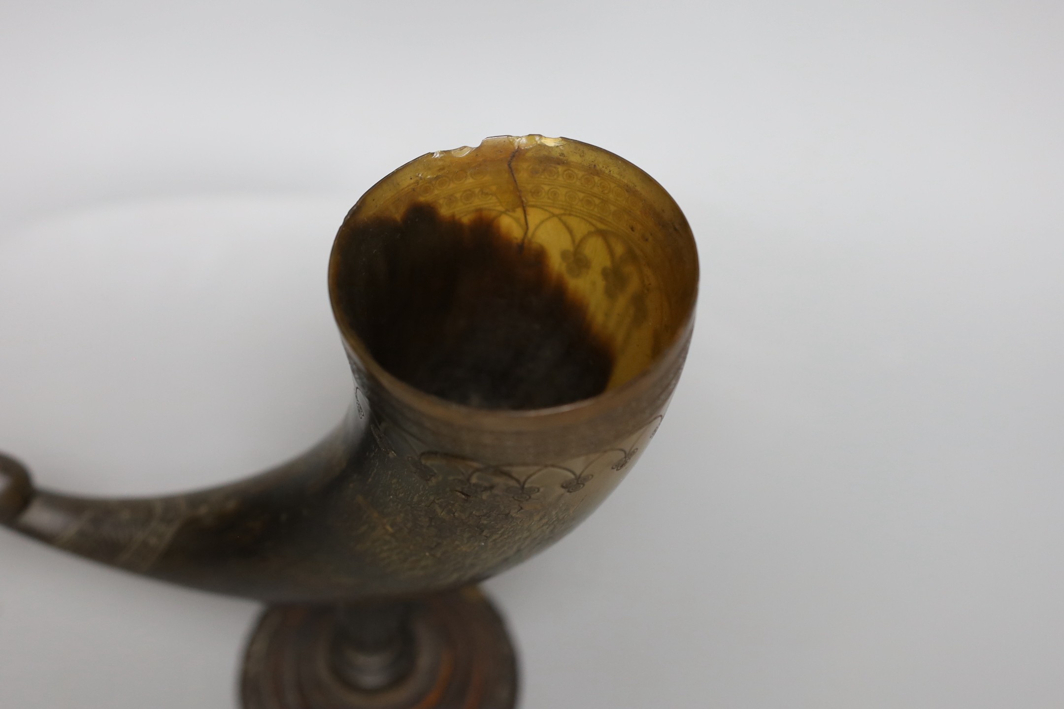 A Persian horn rhyton, 19th century or earlier, with horn stem and stepped wood base, 21cms high, 20.5cm long